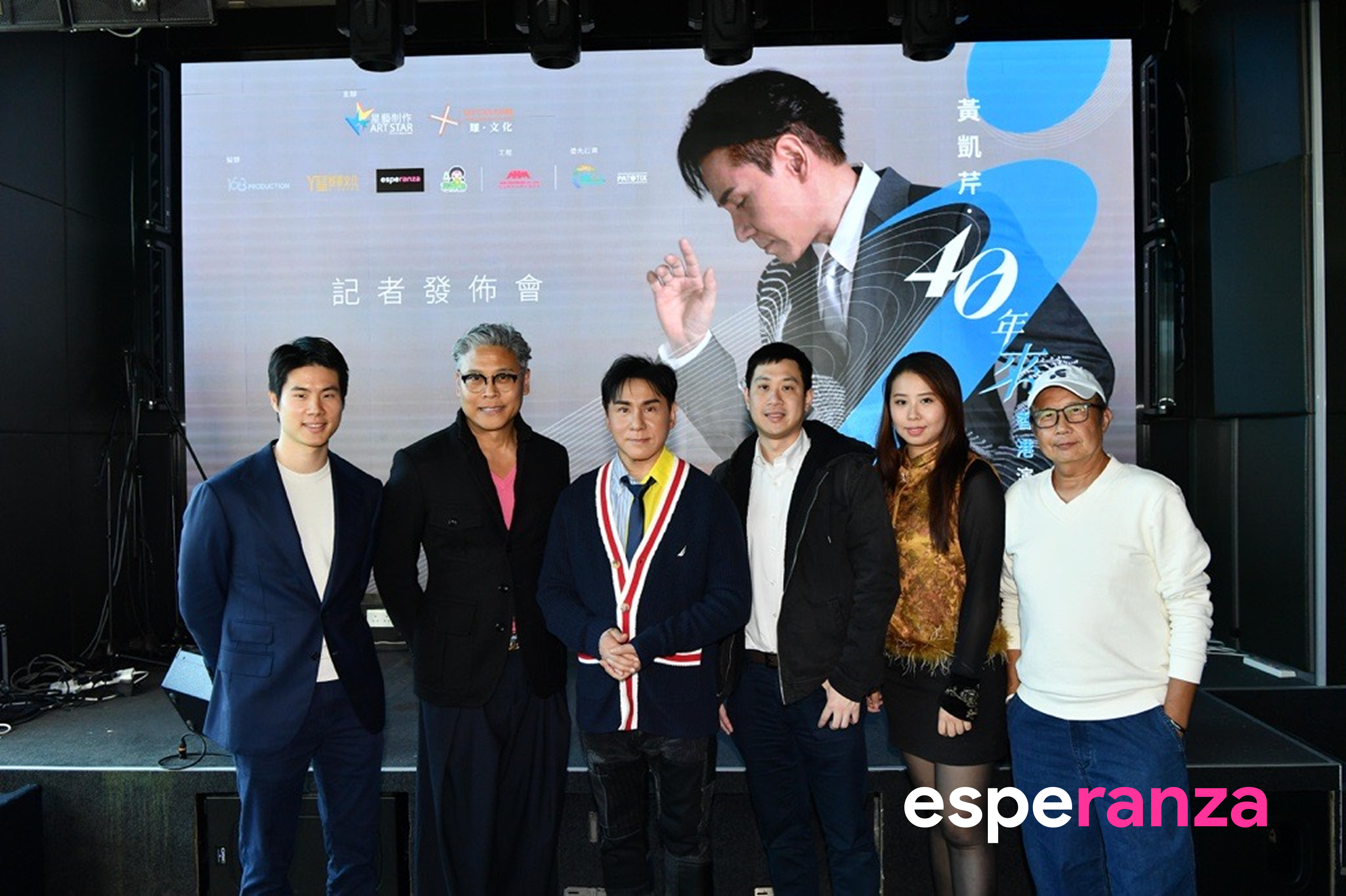 Group photograph in front of the Chris Wong 40th anniversary concert display, from the original company announcement